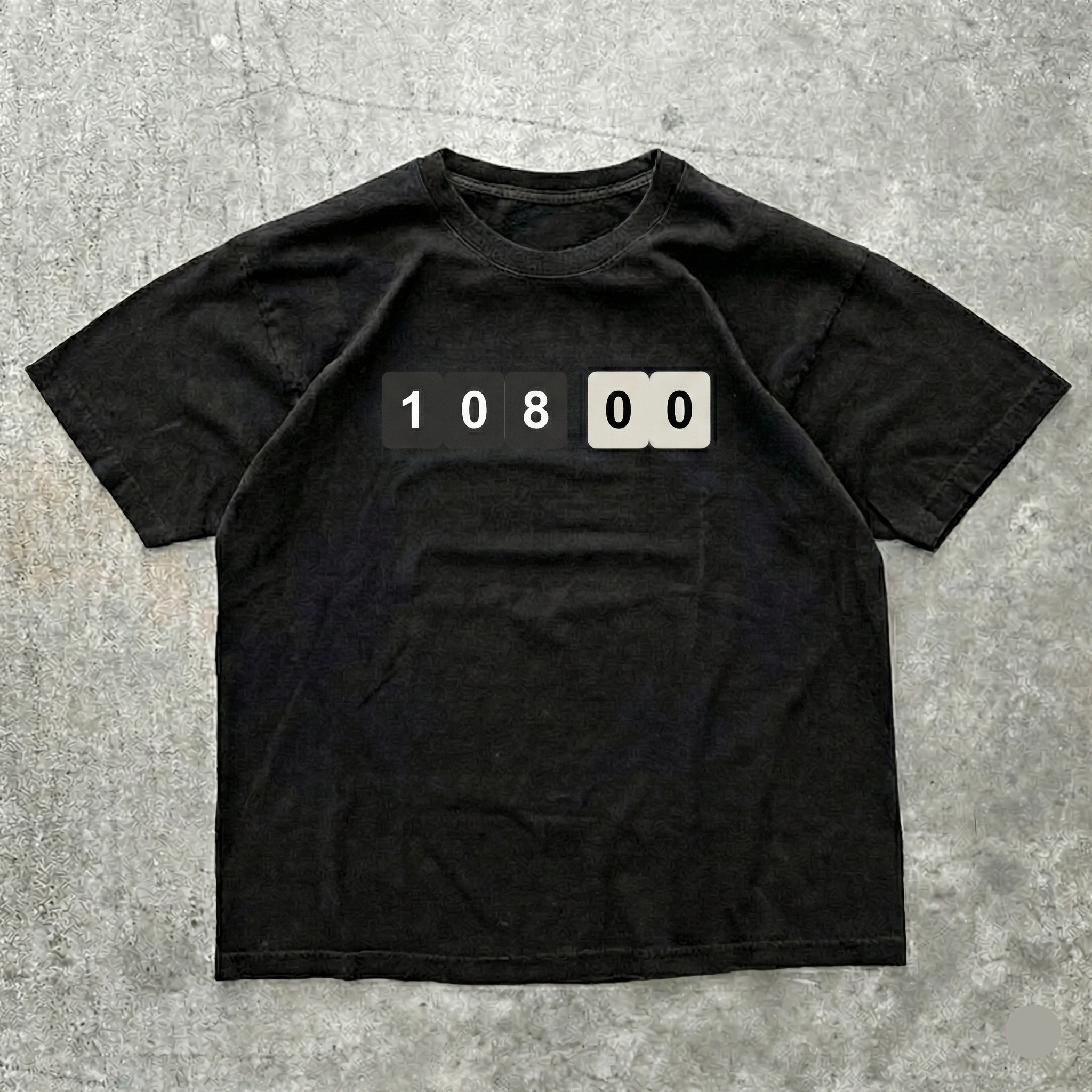 Black t-shirt with a numeric design on a gray concrete surface