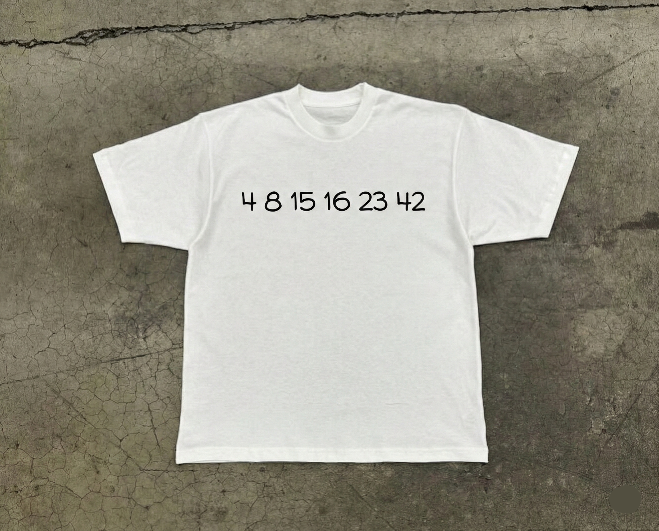 White t-shirt with black text on a textured gray surface