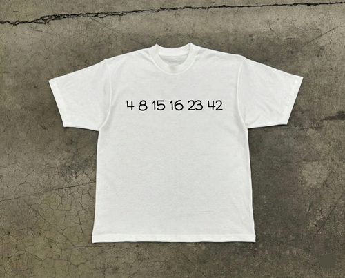 White t-shirt with black text on a textured gray surface